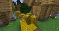 A large stack of hay bales in a village (Image via Minecraft)